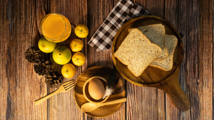 Set of breakfast of the morning, orange juice, whole wheat bread & egg on the wooden dish, top view.