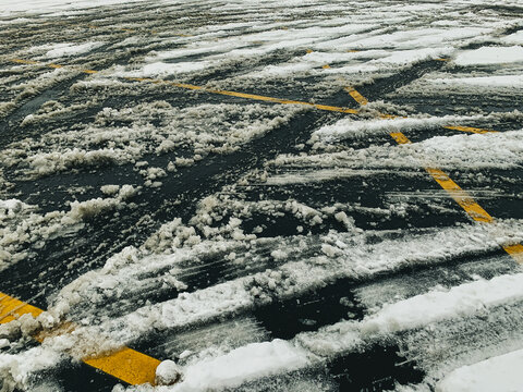 view of a parking lot after a snow storm with crisscrossing lines