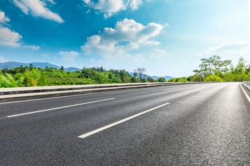 Fototapeta premium Asphalt road and green plants with mountain natural scenery in Hangzhou on a sunny day.