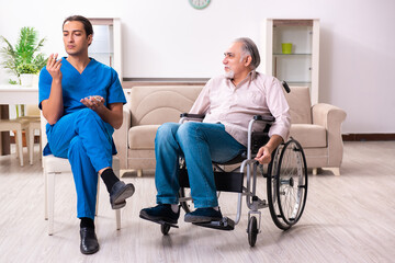 Old man in wheel-chair and young bad caregiver indoors