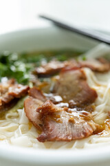 side view bowl of bbq prok with rice noodles vertical composition