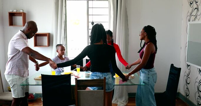 Black African family praying together before meal