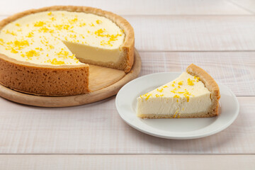 Homemade lemon cheesecake and piece of pie near on plate