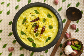 Bowl of homemade  Ash gourd yellow curry spices, buttermilk sour cream curd yogurt Dahi fresh herbs...