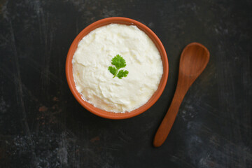 Bowl of homemade sour cream curd yogurt Dahi fresh herbs curry leaf Kerala, India. Dairy product...