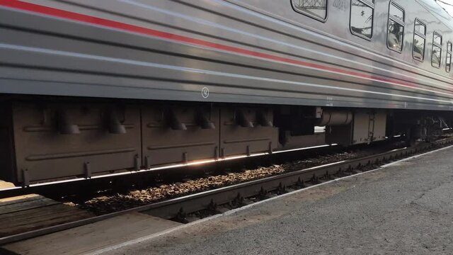 Passenger train is traveling by rail. Close-up of wagon wheels on railway. Transport and freight concept.