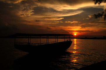 Obraz premium Silhouette of ship on the beach at sunset
