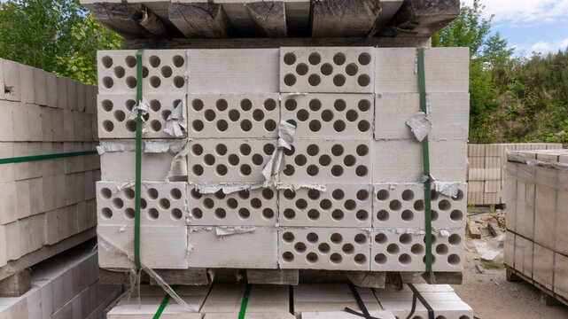 Packed with bandage tapes and stretch film stack of bricks are stacked on wooden pallets in an abandoned warehouse