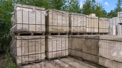 Packed with bandage tapes and stretch film bricks are stacked on wooden pallets in an abandoned warehouse