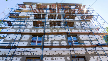 Building with scaffolding under foam insulation
