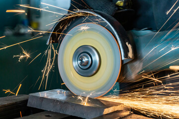 Angle grinder at work, sparks and dust from the cut-off stone.