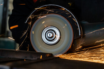 Angle grinder at work, sparks and dust from the cut-off stone.