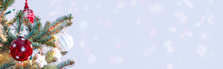 Christmas tree with decorations and glowing holiday lights. Christmas and New Year holiday background with copy space.