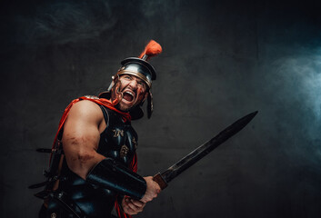 Savage assaulting imperial warrior from ancient rome in dark armour with gladius screaming in...