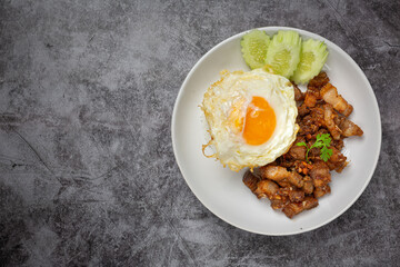Thai food;  fried pork with garlic and pepper served with rice and fried egg