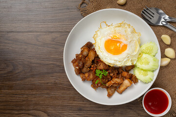 Thai food;  fried pork with garlic and pepper served with rice and fried egg