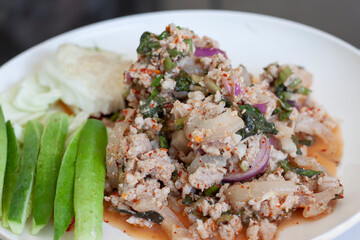 Spicy minced pork with vegetables in a white plate is a Thai food style.