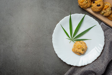 cannabis cookie and cannabis leaf put on white plate