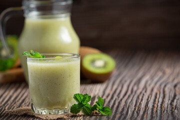 a glass of kiwi juice put on wooden floor