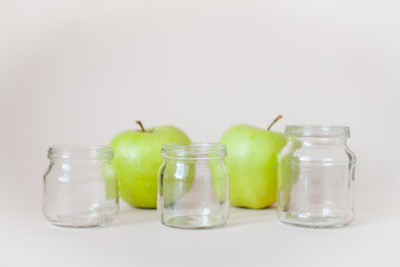 Green ripe apples and empty transparent jars for baby food