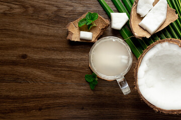 a glass of coconut water put on dark wooden background