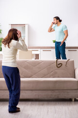 Young couple and snake in the flat