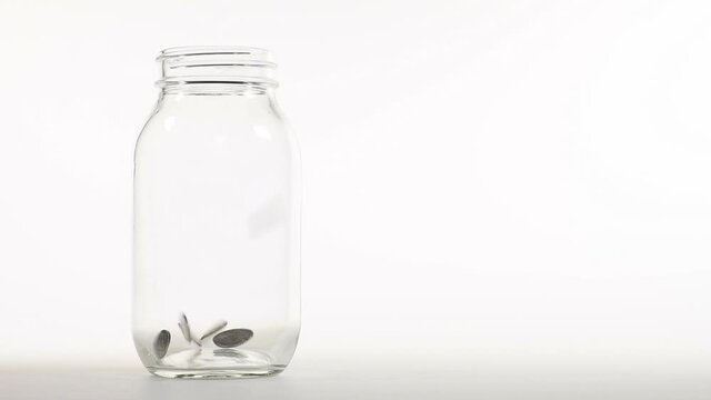 Coins falling into jar - slow motion