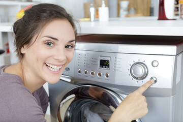 woman loading dirty clothes in washing machine