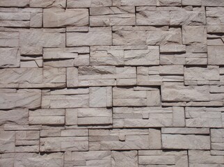 Muro con recubrimiento decorativo en color arena iluminado a la luz del medio día 