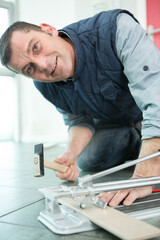 Obraz premium a man cutting a ceramic floor tiles