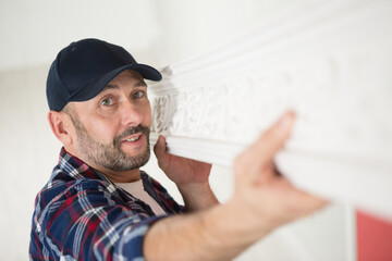 a decorator installing classic moldings © auremar