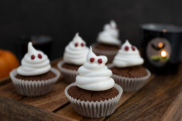 Halloween ghost cupcakes , homemade sweet chocolate muffins with meringue ghost