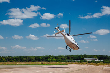 A white helicopter takes off from the runway