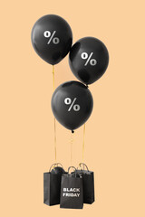 Shopping bags and balloons with percent signs on color background. Black Friday sale