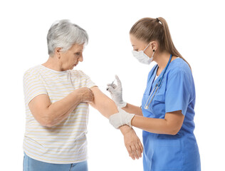 Doctor giving senior diabetic woman insulin injection on white background