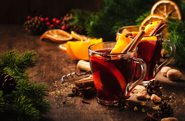 Xmas hot mulled red wine with spices and orange on wooden rustic table. Traditional Christmas or...