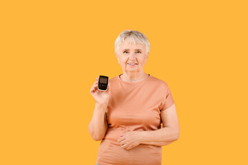 Senior diabetic woman with glucometer on color background