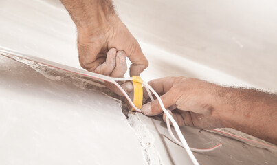 Electrical work. Isolates electric cable with insulation tape