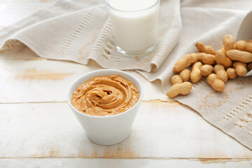 Bowl with tasty peanut butter on table