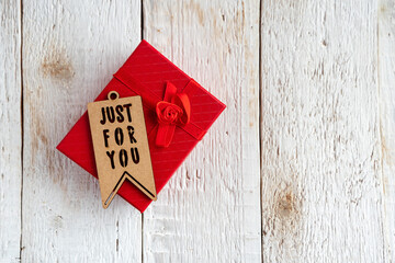 Red gift box and text just for you on a white wooden background