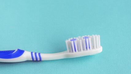 One clean toothbrush on a blue background. Copy space