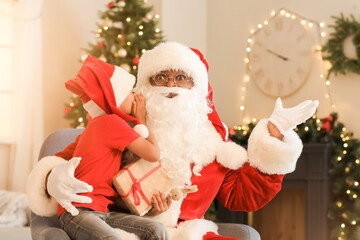 African-American boy telling Santa Claus his wish at home on Christmas eve