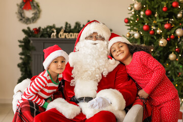 Fototapeta na wymiar African-American Santa Claus with cute children at home on Christmas eve