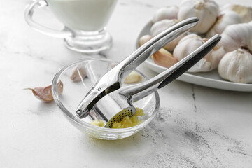Garlic press with bowl on table