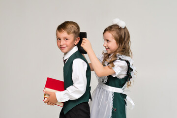 Portrait two elementary school students in uniform with books and tablet pc. New technologies for teaching. Online Education Gadgets. Success, creative ideas and innovation technology