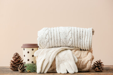 Stylish Christmas clothes on table against color background