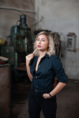 Portrait of a beautiful young blonde woman with blue eyes with old machinery 