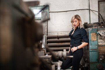 Portrait of a beautiful young blonde woman with blue eyes with old machinery 