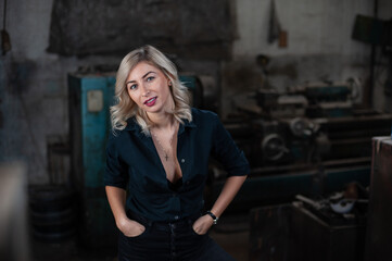 Portrait of a beautiful young blonde woman with blue eyes with old machinery 