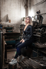 Plakat Portrait of a beautiful young blonde woman with blue eyes with old machinery 